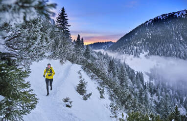 Woman running on mountain path at Heimgarten, Bavaria, Germany - MRF02459