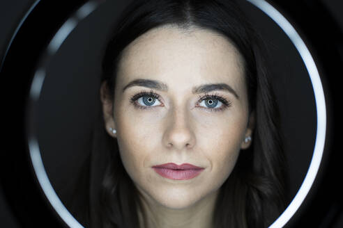 Frau mit rosa Lippenstift durch Ringlicht im Studio gesehen - GIOF10937