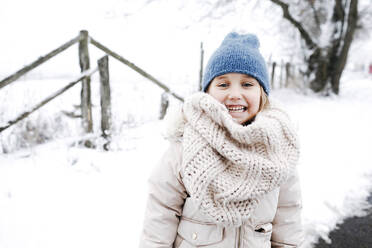 Smiling girl wearing warm clothing during winter - KMKF01506