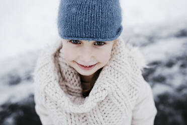 Glückliches kleines Mädchen in warmer Kleidung im Winter - KMKF01518