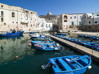 Blaues Boot im Kanal zwischen Gebäuden an einem sonnigen Tag in Monopoli, Apulien, Italien - AMF09022