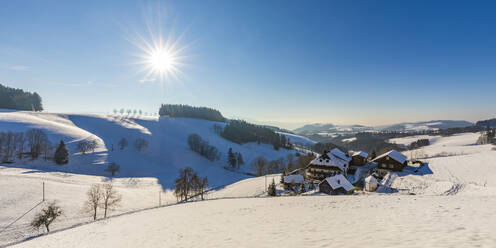 Deutschland, Baden-Württemberg, Sankt Margen, Sonne scheint über die Häuser der Stadt mitten im Schwarzwald im Winter - WDF06521