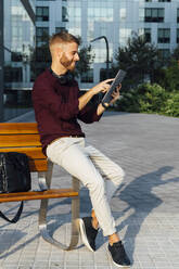 Entrepreneur using digital tablet while sitting on bench - BOYF01678