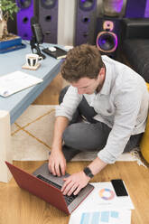 Unternehmer, der einen Laptop bei der Arbeit zu Hause benutzt - BOYF01702
