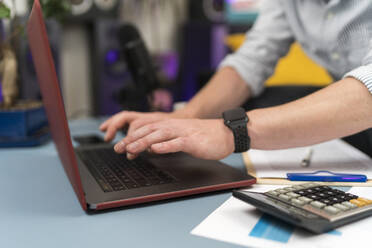 Geschäftsmann mit Laptop bei der Arbeit im Home Office - BOYF01727