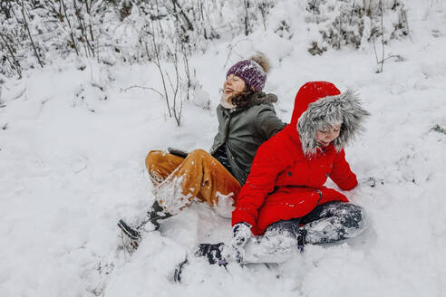 Fröhliche Schwestern beim Spielen im Schnee im Winter - OGF00832