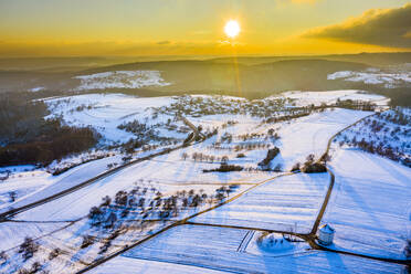 Drohnenansicht von schneebedeckten Feldern bei Wintersonnenuntergang - STSF02798