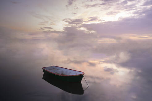 Boot vertäut auf ruhiger See gegen bewölkten Himmel bei Sonnenuntergang - FCF01956