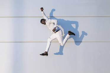 Mann springt durch weiße Wand - MPPF01454
