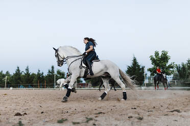 Junge Freundinnen reiten auf einem Bauernhof am Wochenende - MRRF00866