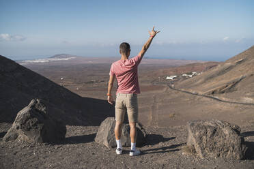 Männlicher Tourist gestikuliert am Femes-Aussichtspunkt, Lanzarote, Spanien - SNF01086