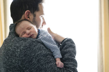 Vater mit schlafendem kleinen Jungen, der am Fenster steht und wegschaut - MPPF01477