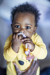 Baby-Mädchen kaut Spielzeug, während es von einem Mann gehalten wird - OCMF02012