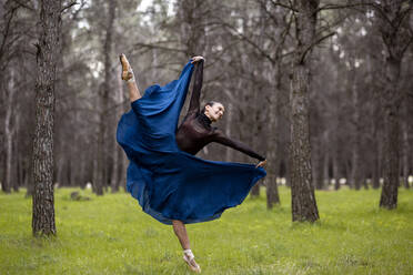 Passionate dancer smiling while dancing in forest - JCCMF01032