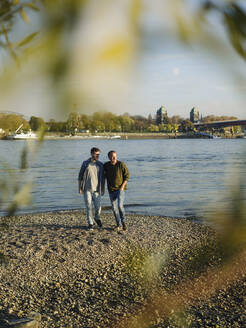 Sohn und Vater verbringen ihre Freizeit am Flussufer an einem sonnigen Tag - GUSF05197