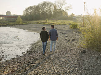 Vater und Sohn gehen im Herbst am Flussufer spazieren - GUSF05203