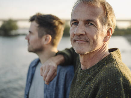 Lächelnder Vater mit Sohn am Flussufer - GUSF05218