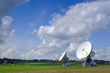 Deutschland, Bayern, Raisting, Wolken über Cassegrain-Antennen im Feld stehend - LBF03328