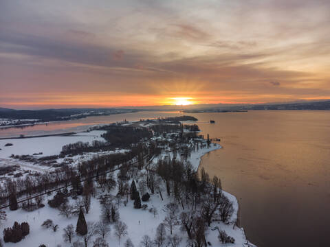Germany, Baden-Wurttemberg, Radolfzell, Aerial view of snow-covered Mettnau peninsula at sunset stock photo