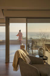 Frau auf luxuriöser Veranda mit Blick auf das Meer - CAIF30244