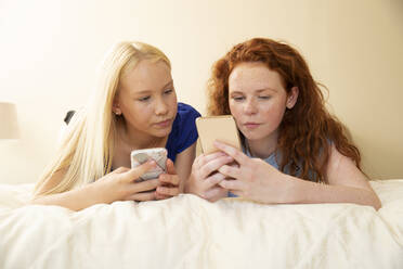 Preteen-Freundinnen benutzen Smartphones im Bett - CAIF30249