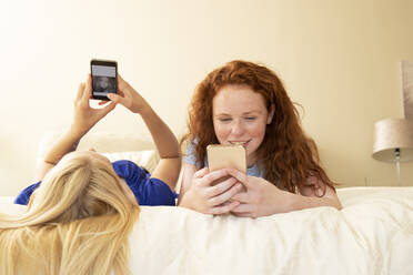 Preteen-Freundinnen benutzen Smartphones im Bett - CAIF30257