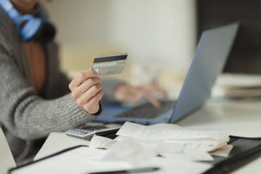 Close up Frau mit Kreditkarte zahlen Rechnungen online am Laptop - CAIF30282