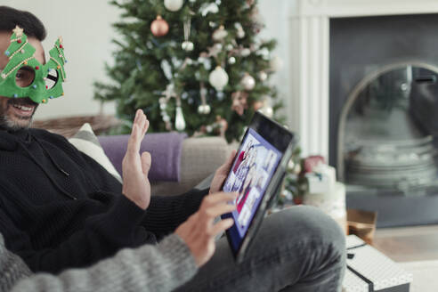 Ehepaar unterhält sich an Weihnachten per Videochat mit der Familie über ein digitales Tablet - CAIF30283