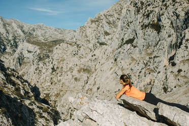 Forscher mit Blick auf die Berge bei einer Rast auf dem Cares Trail im Nationalpark Picos De Europe, Asturien, Spanien - DMGF00457