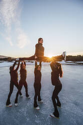 Eiskunstläuferinnen üben auf einem zugefrorenen See bei Sonnenuntergang - RSGF00539