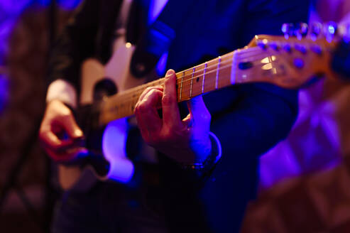 Männlicher Gitarrist spielt Gitarre im Studio - PGF00399