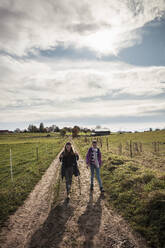 Mädchen erkunden bei einem Spaziergang durch ein landwirtschaftliches Feld auf dem Lande - DHEF00522