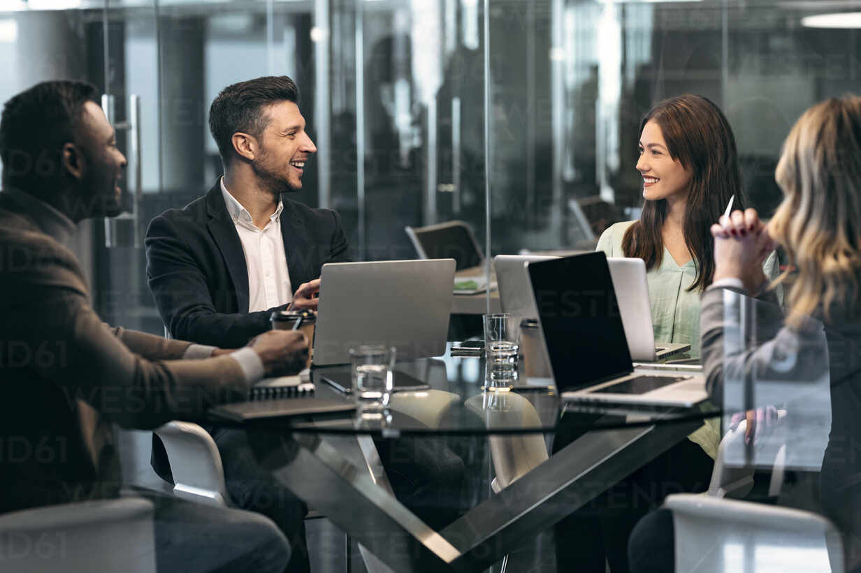 Smiling business people having discussion in meeting while sitting at office  stock photo