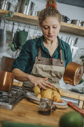 Koch beim Marinieren von Fleisch während der Arbeit in der Küche - MFF06965