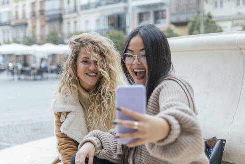 Fröhliche Freundinnen nehmen Selfie durch Smartphone - JRVF00238