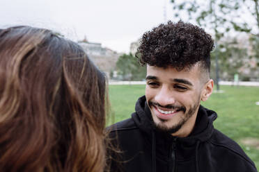 Lächelnder junger Mann mit Freundin in einem öffentlichen Park - XLGF01107