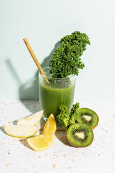 Healthy green juice with apple, lemon, kale, kiwi and celery against wall - GEMF04634