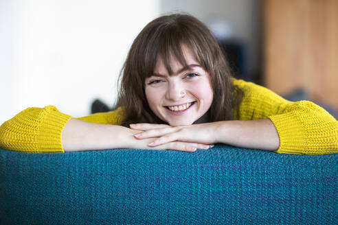 Happy woman resting on sofa at home - SGF02744