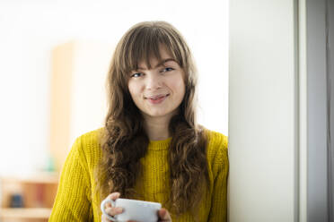 Schöne Frau mit langen Haaren hält Tasse zu Hause - SGF02749