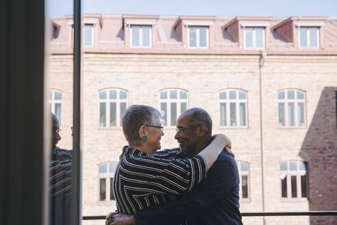 Heterosexuelles Paar umarmt sich auf dem Balkon - MASF21423