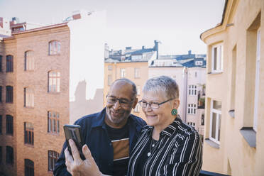 Älteres Paar macht Selfie mit Handy auf Balkon - MASF21426