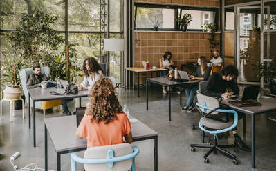 Female and male colleagues working at coworking office - MASF21498