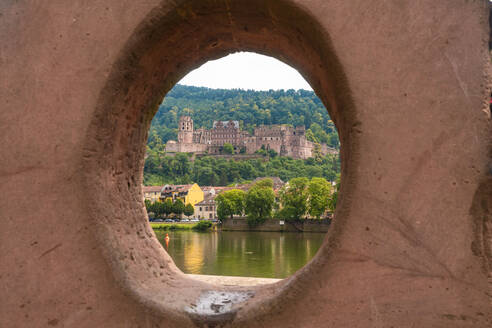 Deutschland, Baden-Württemberg, Heidelberg, Heidelberger Schloss durch kreisrundes Loch aus Liebesstein-Sandstein gesehen - TAMF02889