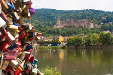 Germany, Baden-Wurttemberg, Heidelberg, Heidelberg Castle with padlocks of Liebesstein in foreground - TAMF02890