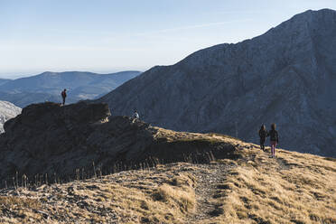 Männliche und weibliche Wanderer auf Erkundungstour in den Bergen gegen den Himmel - JAQF00238