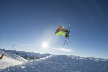 Männlicher Skifahrer springt gegen den Himmel - DAMF00695