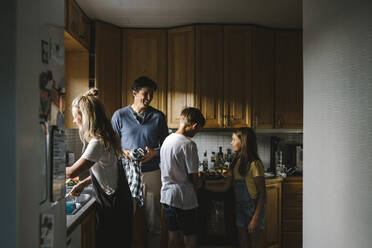 Happy family doing chores in kitchen at home - MASF21503