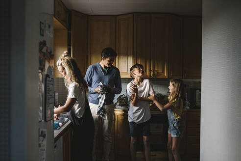 Geschwister mit Eltern in der Küche stehend - MASF21505