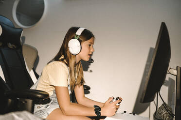 Kaukasisches Mädchen, das zu Hause vor dem Fernseher ein Videospiel spielt - MASF21528