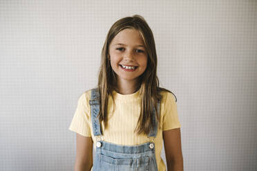 Smiling girl against white wall at home - MASF21540